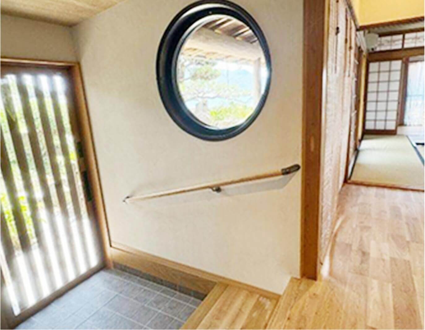 丸窓のある玄関と、廊下の先に続く畳の和室